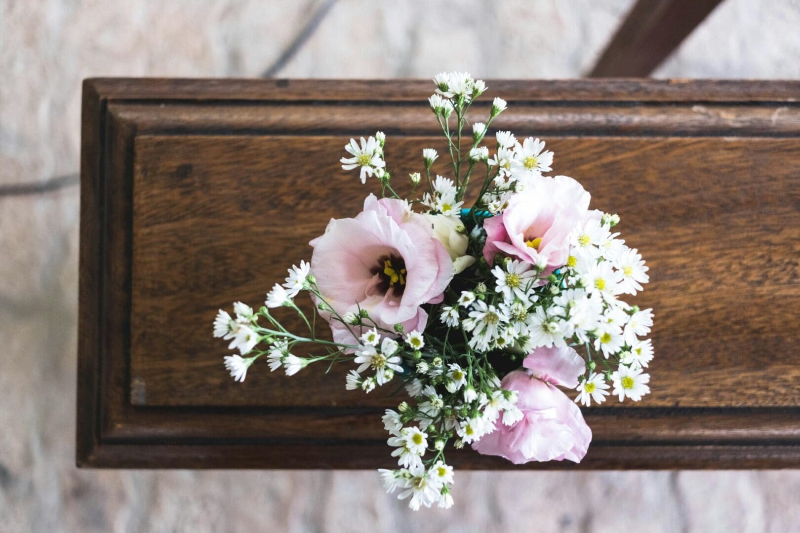 A bouquet of flowers on top of a wooden table.